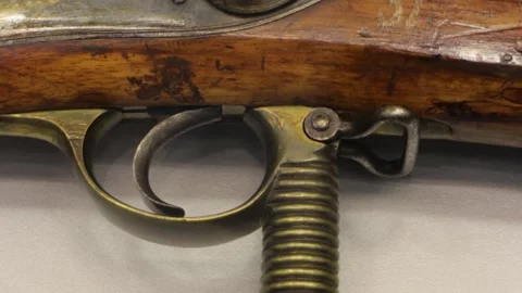 The trigger of an antique flintlock rifle Stockbeeldmateriaal 334339525