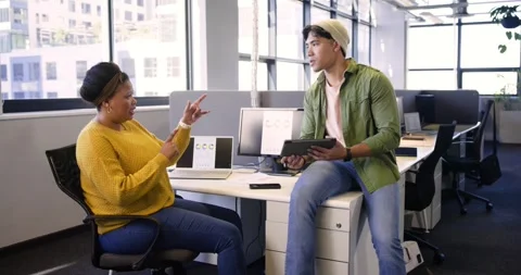 Triggered by tablet chart, diverse coworkers reviewing data on laptop and tablet Stock Footage 336784021
