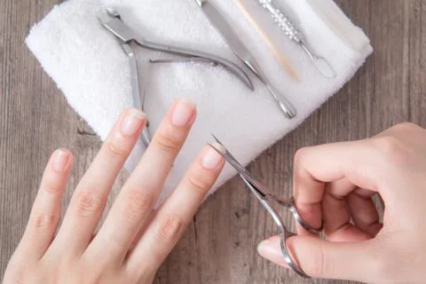 Trim the nails on the hand. Do yourself a manicure. Shorten long nails. Home  库存照片