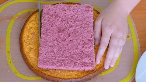 Trim the sides of the biscuit colored cake Stock Footage 123576724