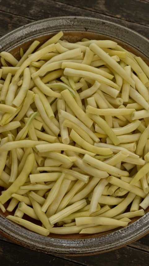 Trimmed and sliced yellow string beans in a bowl. Vertical video. Stock Footage 281177905