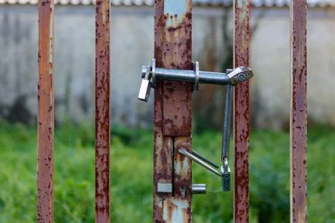 Triple padlocks on a rusty metal gate Stock Photos