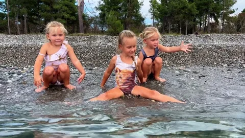 Triplets sisters on the beach 库存影片 252489946