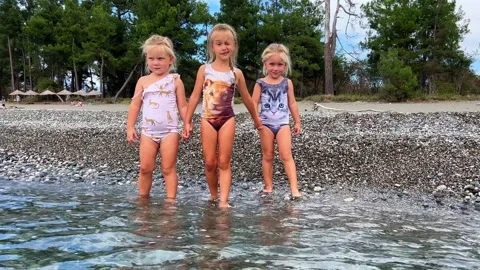 Triplets sisters on the beach 库存影片 252489968