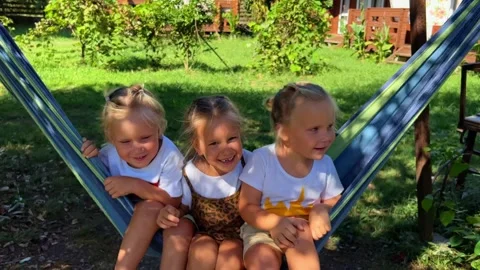 Triplets Sisters swinging on a hammock 库存影片 252490822