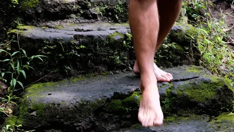 Tripod shot of a barefooted man walking down the mossy stairs towards Aling-A Stock Footage 286003794