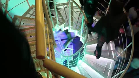 Tripod shot of people walking up and down the steel winding staircase. Stock Footage