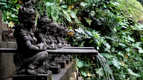 Tripod shot of running to pool for pilgrims water nearby Air Terjun Jagasatru Stock Footage 286001101