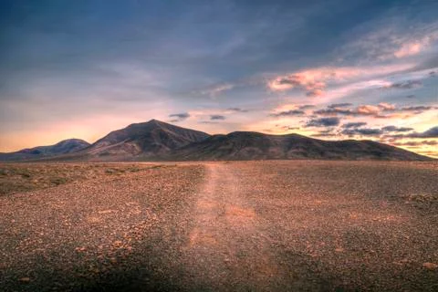 Trodden path leading over time to the mountains Stock Photos