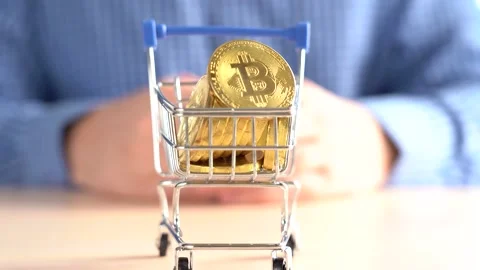 Trolley with bitcoins on the background of a man. Hand gesture Video stock 156880853