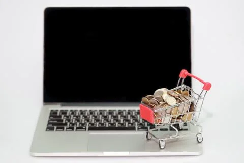 Trolley with coins on computer isolated, idea for shopping and online payment Stock Photos