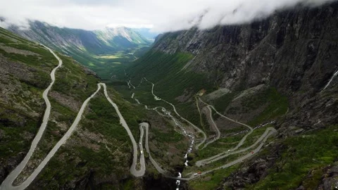Trolls path road curving down the mountain valley on a cloudy day, Norway Video stock 252764491
