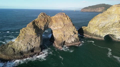 Trolly Shot Flying Backwards From Large Arch at Three Arch Rocks on Sunny Day Stock Footage 228760345