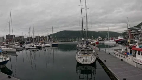 Tromso marina floating dock with moored sailboats and Tromso Bridge view Norway 库存影片 341697377