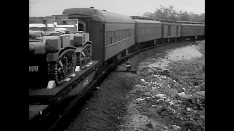A troop train speeds across the US in 1943 delivering goods for the war effort. Stock Footage 79432123