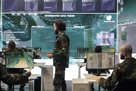 Trooper examining real time reconnaissance data on big screen Stock Photos