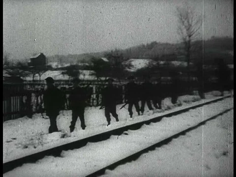 Troops advance through snow and ice on foot and driving trucks and jeeps and a Stock Footage