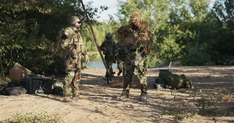 Troops dressed in uniform secure the area of the army base, men with long rifles Stock Footage 169385225
