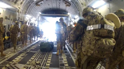 Troops getting off of a C-17 jet and putting boots on the ground for the Stock Footage 115062374