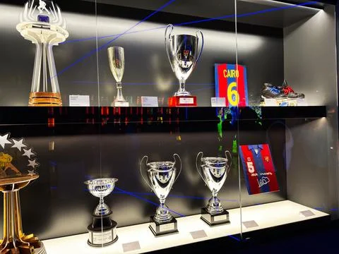 Trophy display case with silver cups, football jersey and cleats at a museu.. Stock Photos