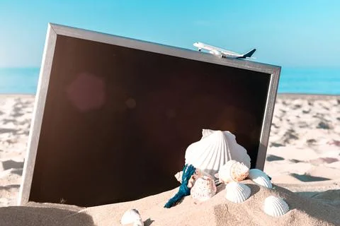 Tropical background. Globe, seashell, airplane and starfish near black desk o Stock Photos