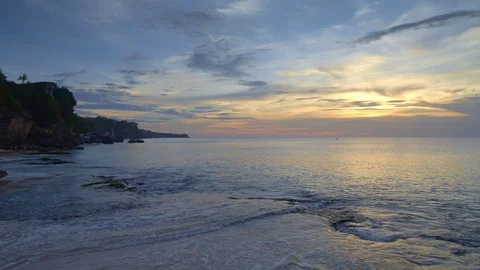 Tropical beach with big waves and cliff during sunset with people Video stock 113271679