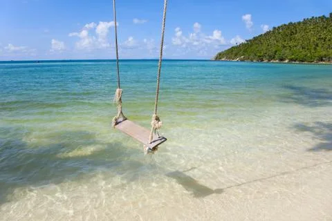 Tropical beach with coconut palm trees  and Old  Swing Tied to   Tree Foto stock