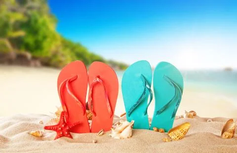 Tropical beach with colored flip flops, summer holiday background. Foto stock