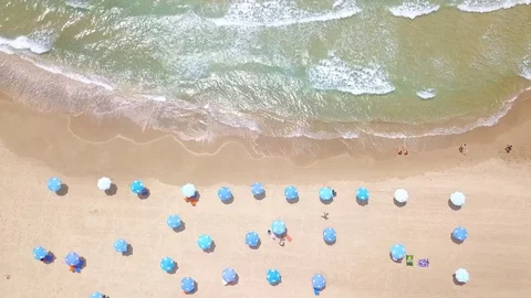 Tropical beach with colorful umbrellas - Top down aerial view Stock Footage