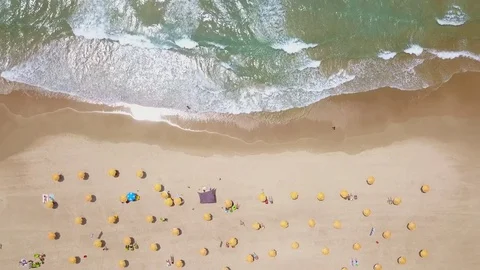 Tropical beach with colorful umbrellas - Top down aerial view Stock Footage