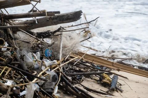 Tropical beach completely covered with garbage and waste. Ecological disaster Stock Photos