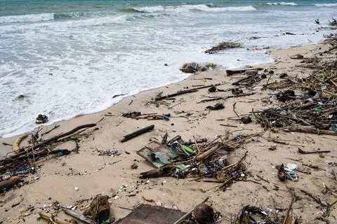 Tropical beach completely covered with garbage and waste. Ecological disaster Stock Photos