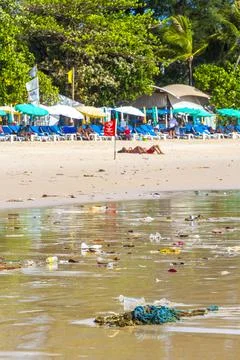 Tropical beach disaster with floating plastic waste and disgusting polluted.. Stock Photos