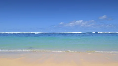Tropical beach during low tide with small waves in ocean and huge waves Stockbeeldmateriaal 115035569