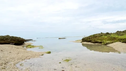 A tropical beach featuring large mossy rock formations on the sand. Stock Footage 329627345