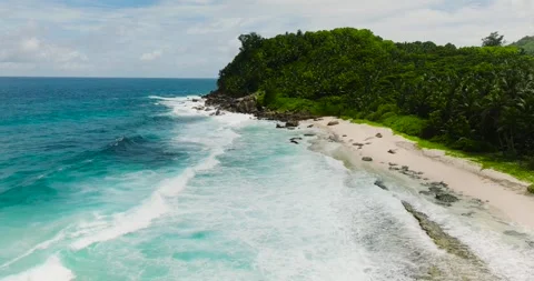 Tropical beach with green forest and waves hitting the shoreline. Seychelles Stock Footage 322015010