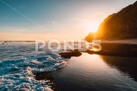 Tropical beach with ocean, waves and sunshine at sunset in Bali Stock Photos