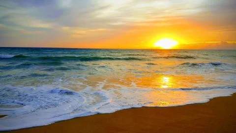 Tropical beach sunset with wave in the sea at Maichao beach in Phuket city, T Stock Photos