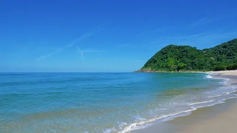Tropical Beach with Turquoise Waves and Forested Hill Vídeos de archivo 343384333