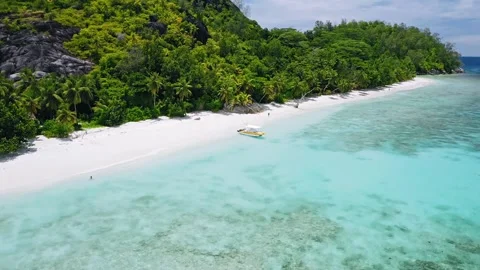 Tropical beach view with crystal-clear water, a white sandy shore, and lush.. Stock Footage 304113273