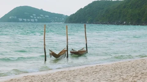Tropical beach with white sand, turquoise sea and two hammocks hanging over Stock Footage 312813875