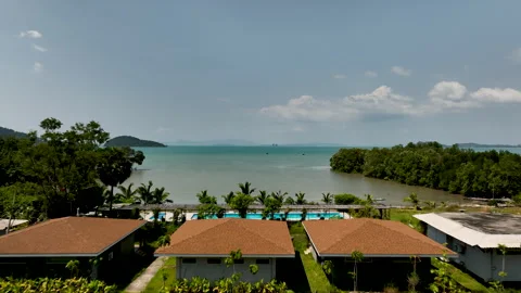 Tropical beachfront villas overlooking a turquoise bay Stock-Footage 303370489