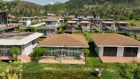 Tropical beachfront villas overlooking a turquoise bay Видео 303370757