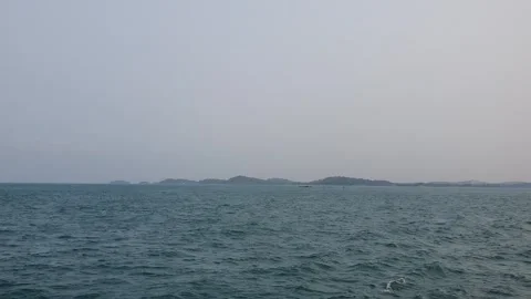 Tropical blue sea surface with tiny distant island Stock Footage 345485473