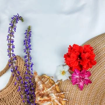 Tropical Flat Lay with Straw Hat Woven Bag and Vibrant Flowers. Stock Photos