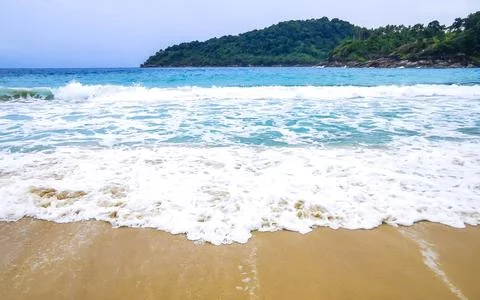 Tropical Freedom Beach waves beneath rain clouds Karon Phuket Thailand. Stock Photos