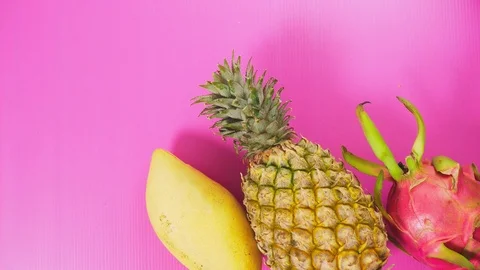 Tropical fruit on a bright pink background. Minimal fruit concept. Stock Footage 100467343