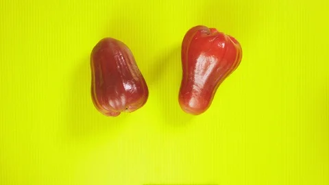 Tropical fruit on a bright yellow background. rambutans and rose apple. Minimal Video stock 100288693