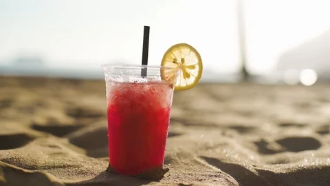 Tropical fruit cold refreshing drink of red color with a slice of lemon Stock Footage 99702710