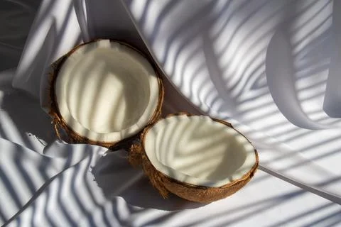 Tropical fruit concept, Two halves of fresh coconut on white fabric backgro.. Stock Photos